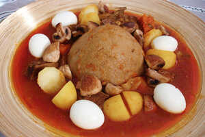 バジンと呼ばれる種なしパンを中央に、野菜のシチューとゆで卵を添えた食事